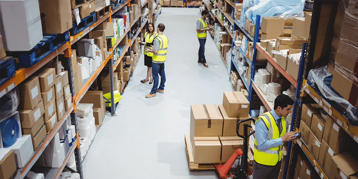 Workers checking temperature and humidity readings in warehouse