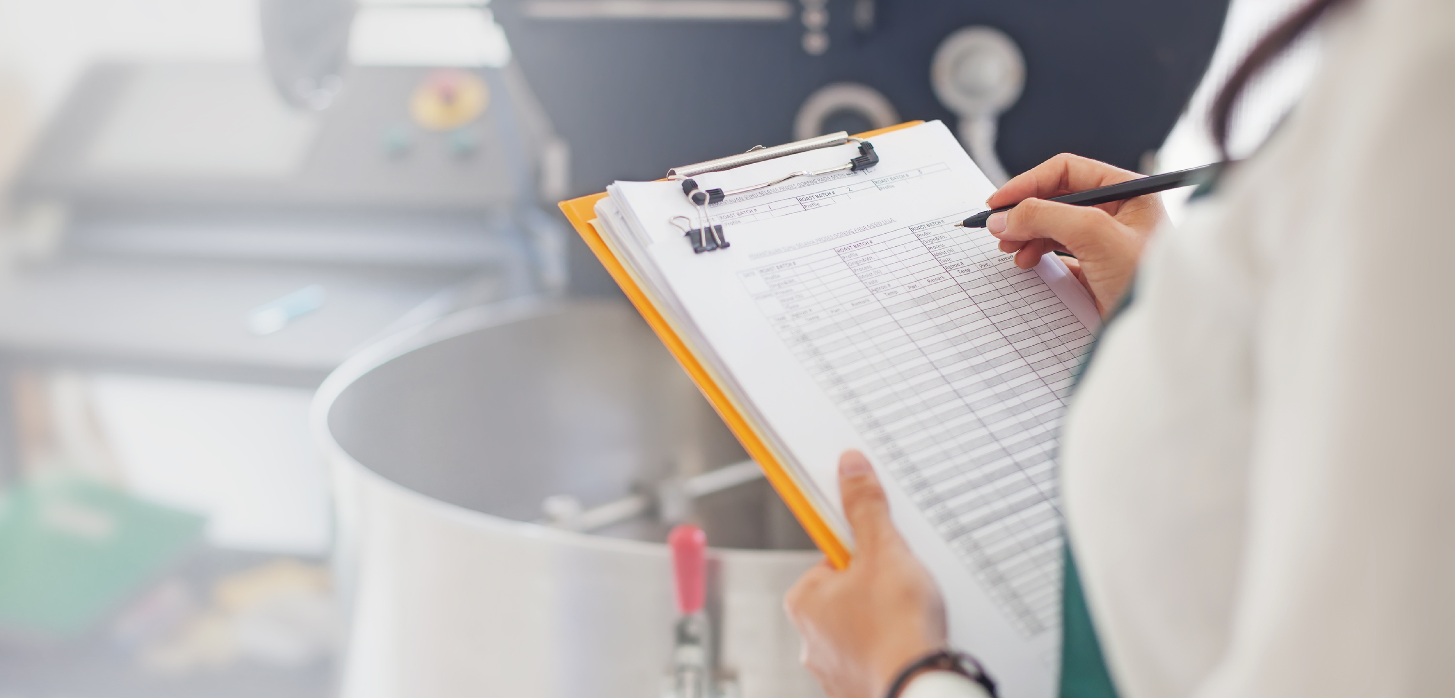 Food production manager checking off a list at food plant