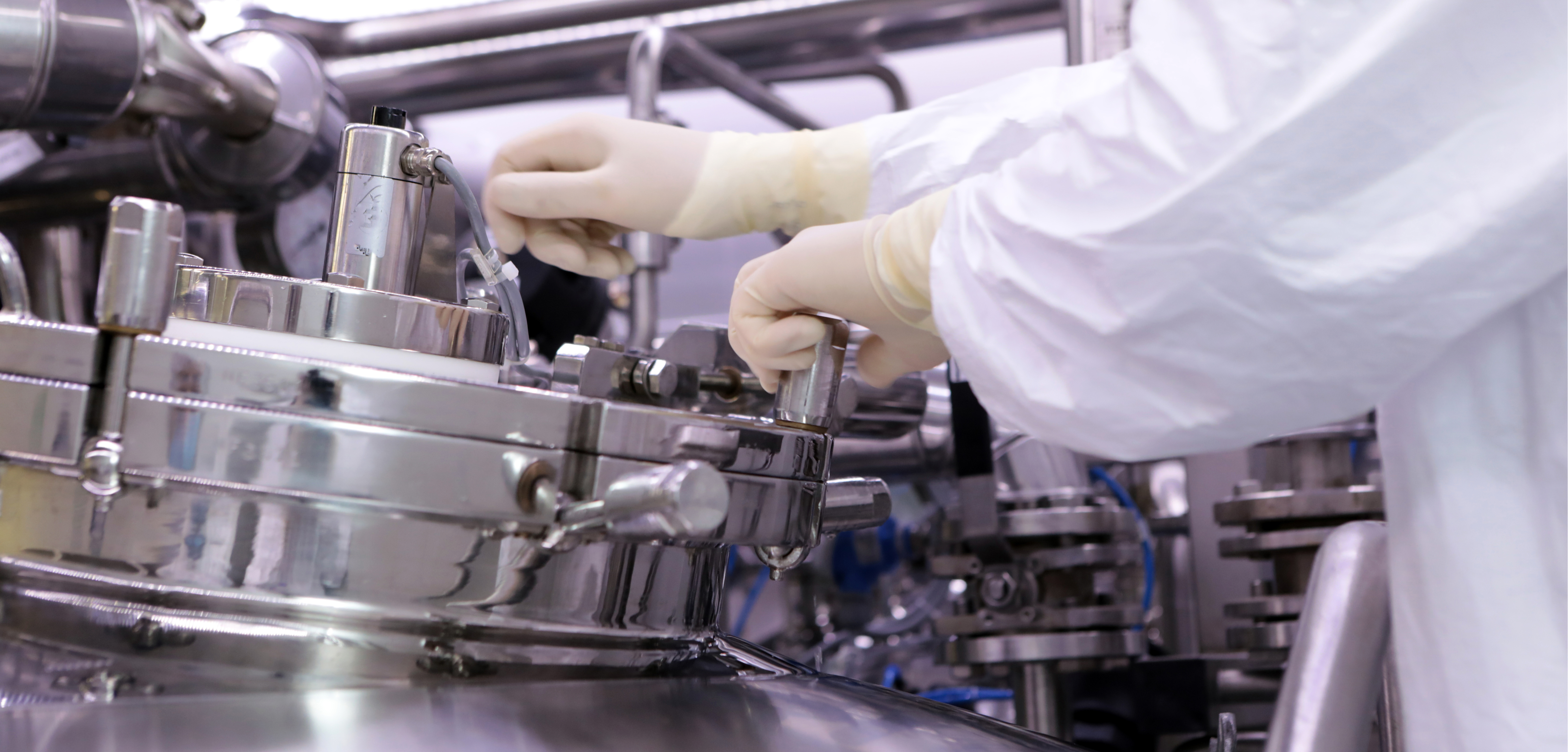 Pharmaceutical manager adjusting a reactor in drug manufacturing plant