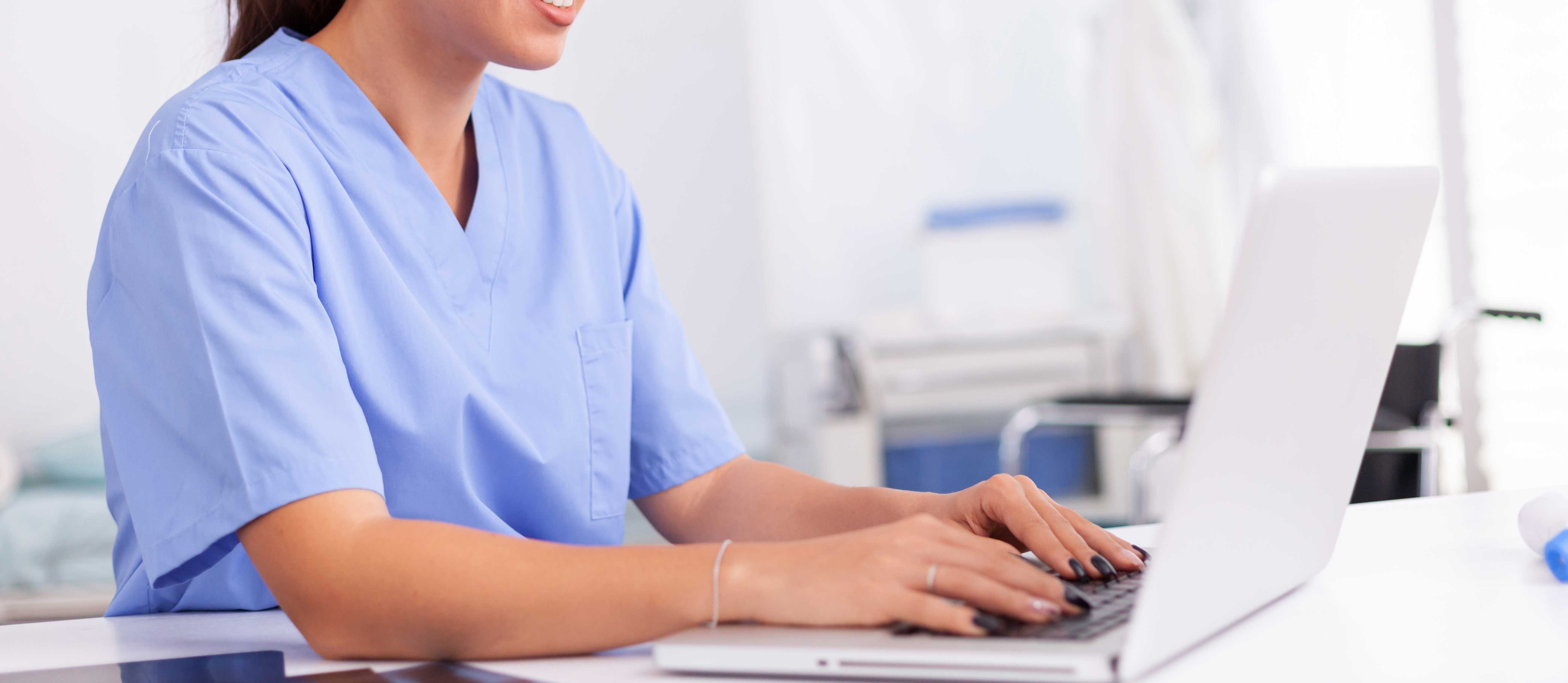 medical-nurse-uniform-using-laptop-sitting-desk-hospital-office-health-care-physician-using-computer-modern-clinic-looking-monitor-medicine-profession-scrubs
