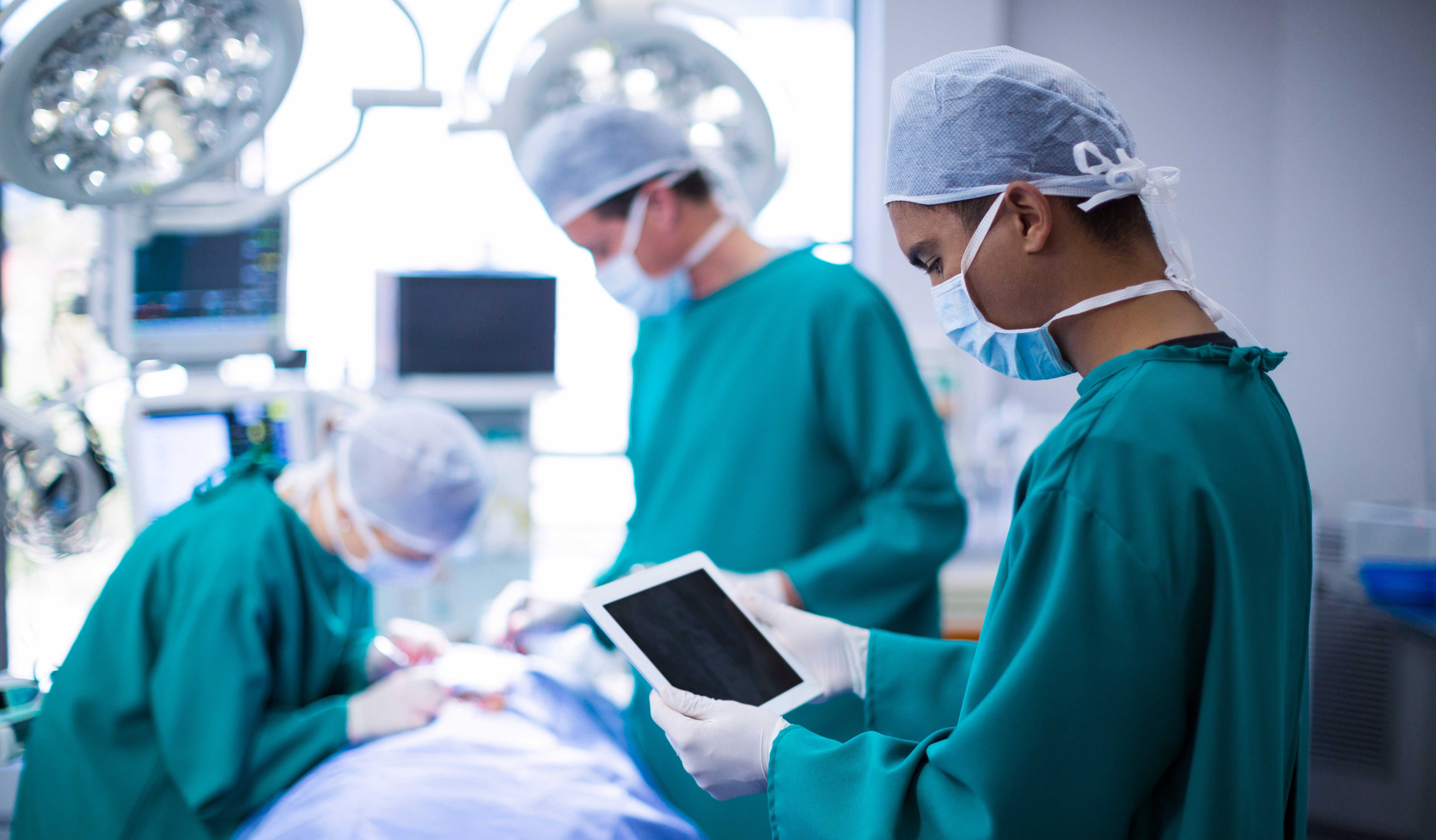 surgeon-using-digital-tablet-operation-theater