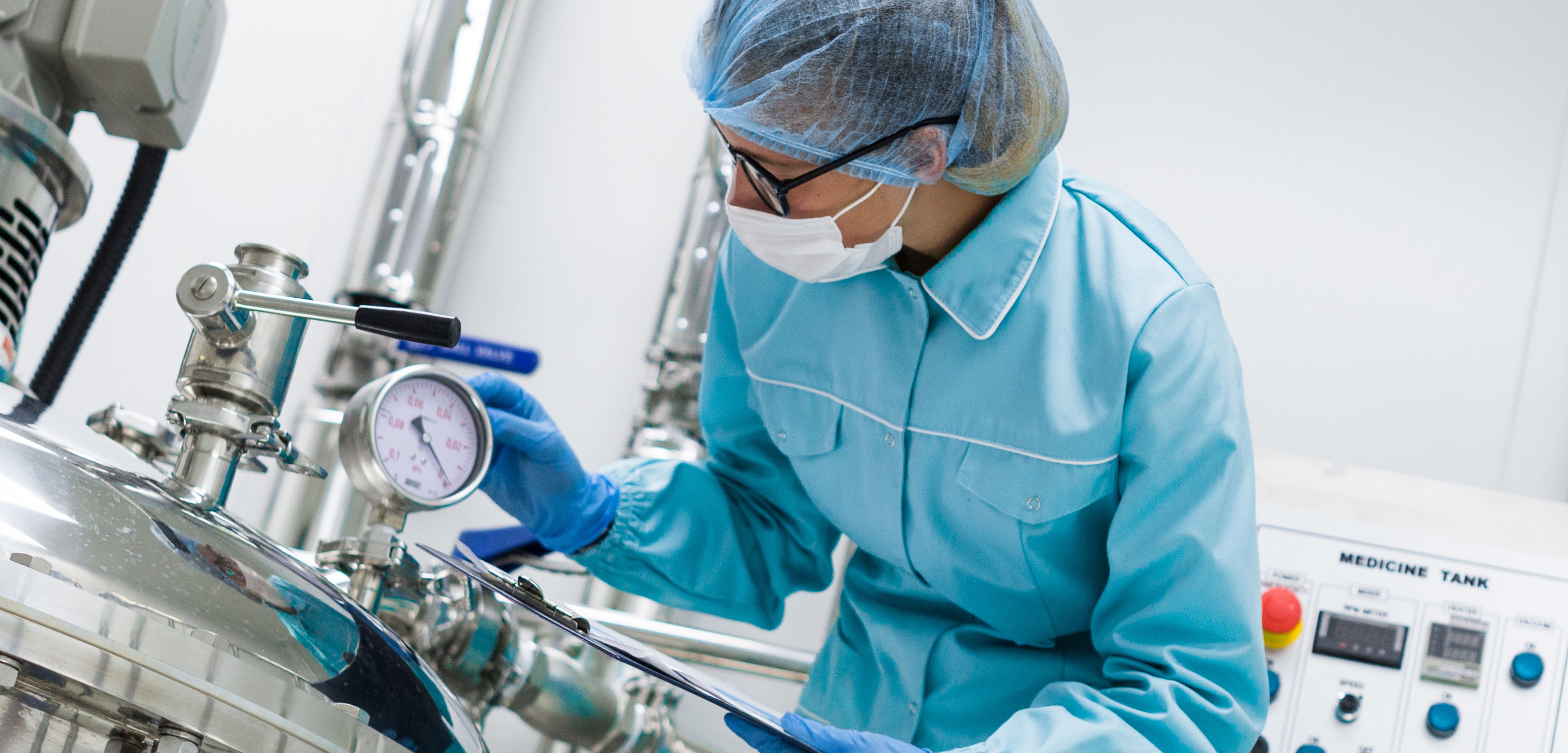 Pharmaceutical worker controlling temperatures in drug laboratory
